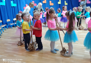dzieci tańczą z miotłami